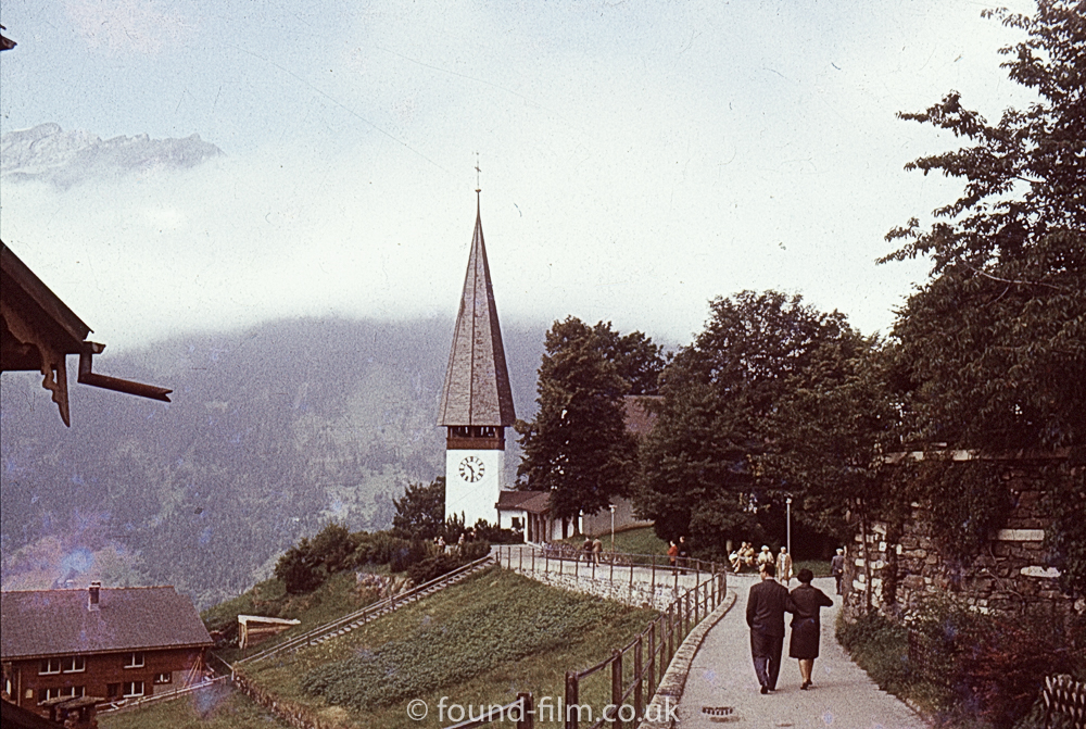 A couple walking along path towards a church in the mountains