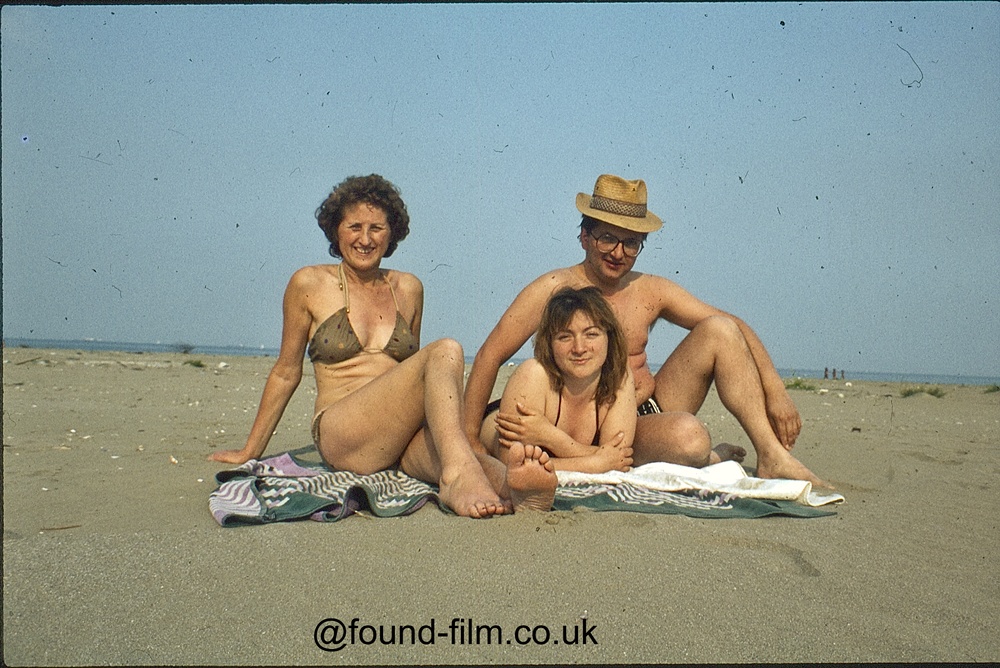 Family relaxing on towels on a beach