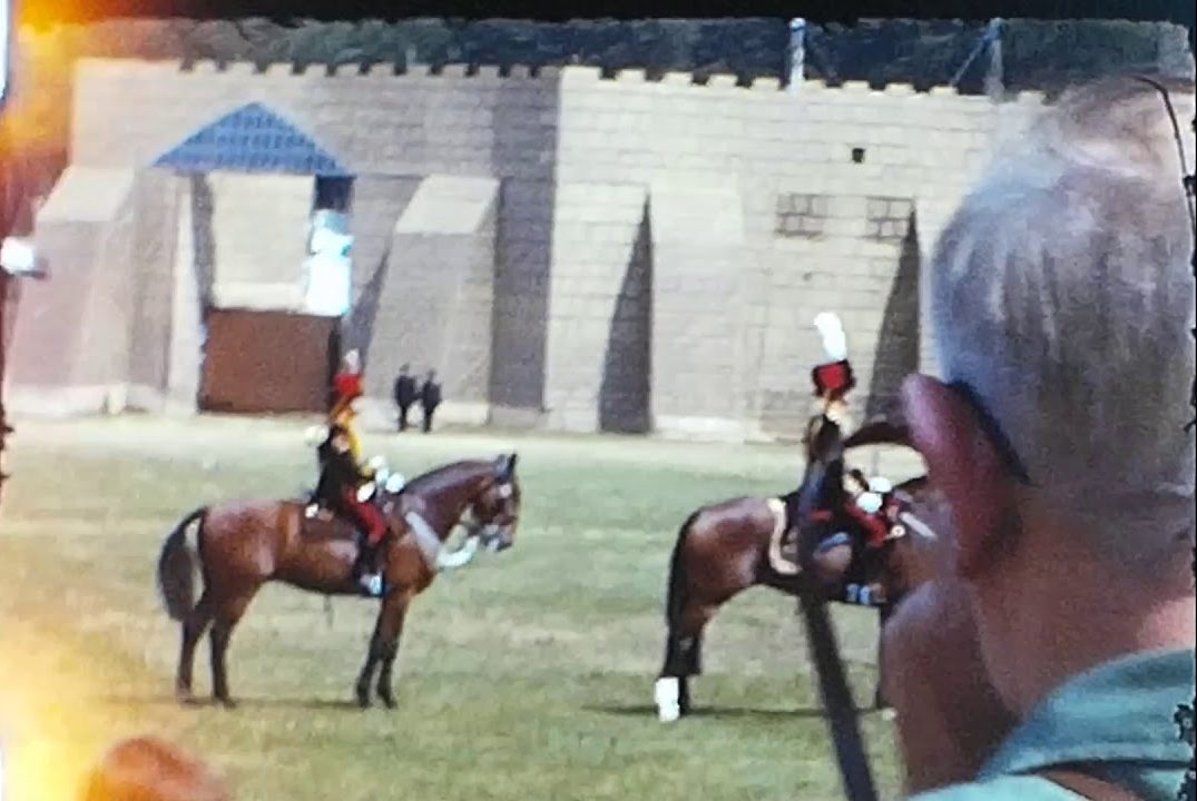 A still from a vintage home movie showing a military display at Aldershot