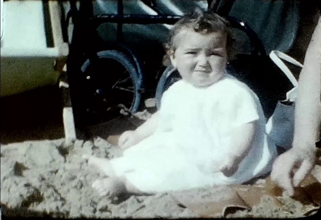 A still picture from a vintage home movie showing a family beach holiday in 1955