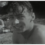 A still shot showing a from a vintage home movie of a beach party in the 1950s