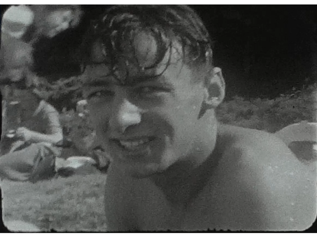 A still shot showing a from a vintage home movie of a beach party in the 1950s