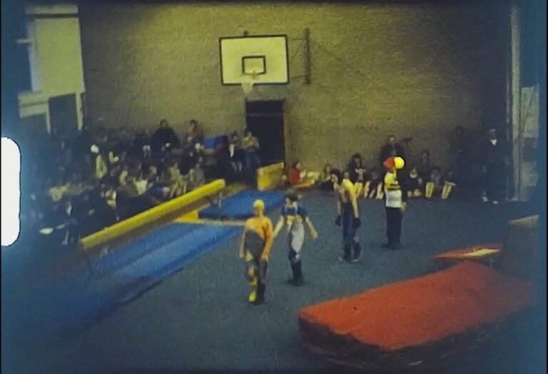 A still image from a Vintage Home Movie shot at a gymnastics display on Super 8 film.