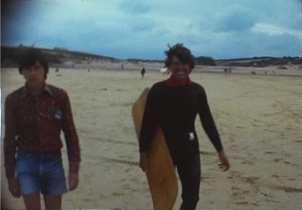 A Still image from a vintage home movie taken in the 1970s of a couple surfing in the uk
