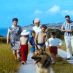 A still image from a vintage home movie showing a family on holday by the seaside