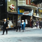 A still image showing a row of shops from a vintage home movie taken in Germany and Holland in 1961