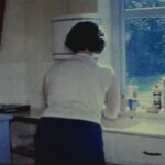 A still image from a vintage home movie of a typical family house of the 1950s