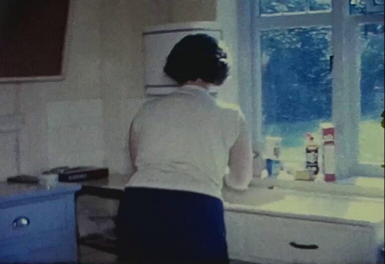 A still image from a vintage home movie of a typical family house of the 1950s