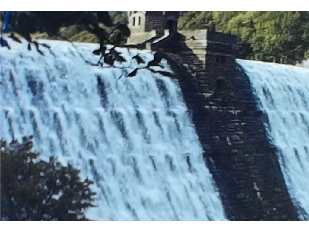 A large weir of waterfall featured in a film showing a livestock farm.