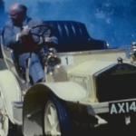 A clip from a vintage home movie featuring a vintage car display from 1962
