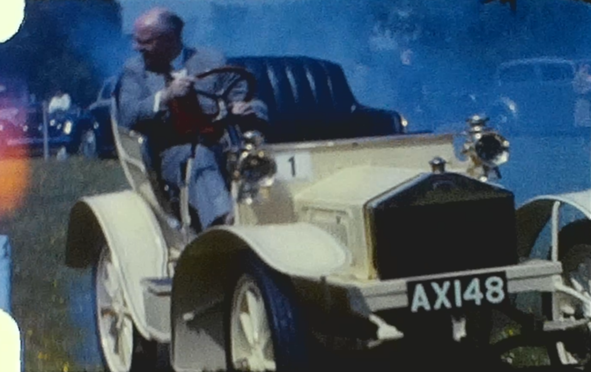 A clip from a vintage home movie featuring a vintage car display from 1962