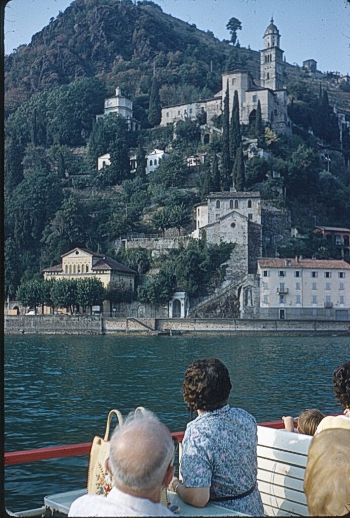 a castle in the side of a hill on a swiss lake