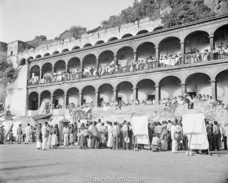 A crowd by an arched building