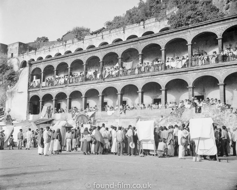 A crowd by an arched building