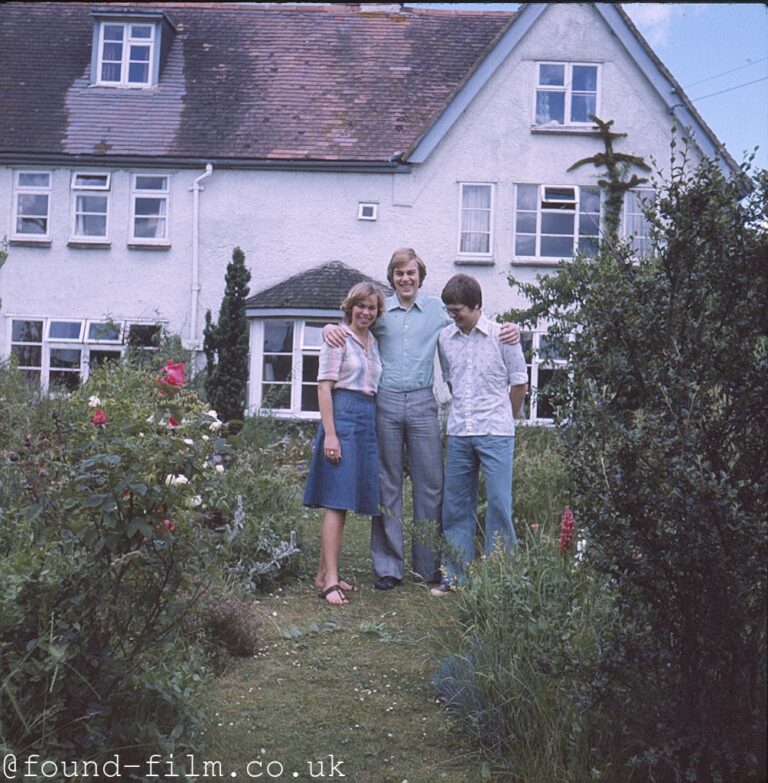 A family group standing in the garden of their cottage