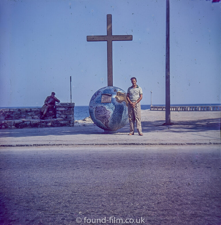 A portrait by a globe with a cross