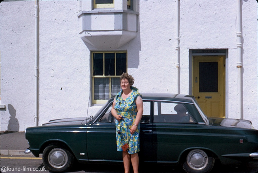 a lady standing by her car