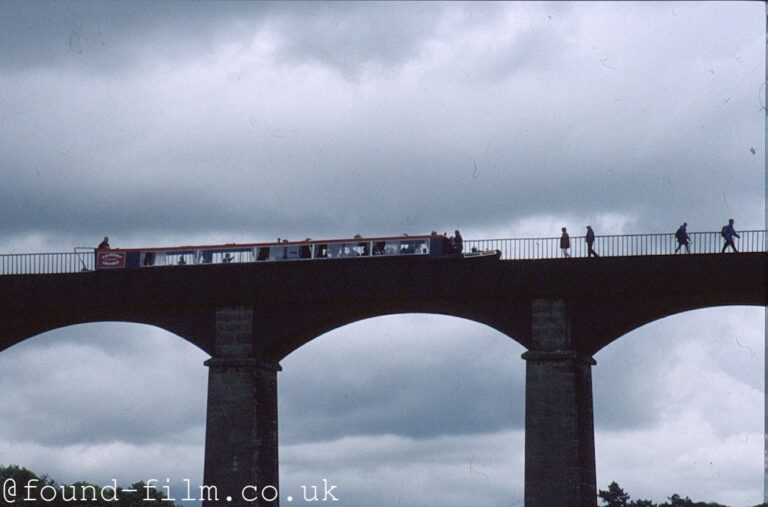 A narrow boat crossing a tall aqueduct