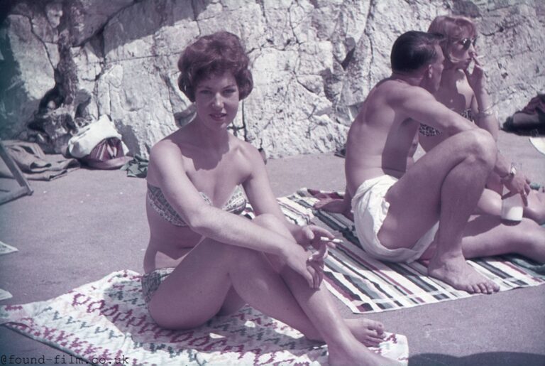 A Pretty girl sitting on a towel with a cigarette