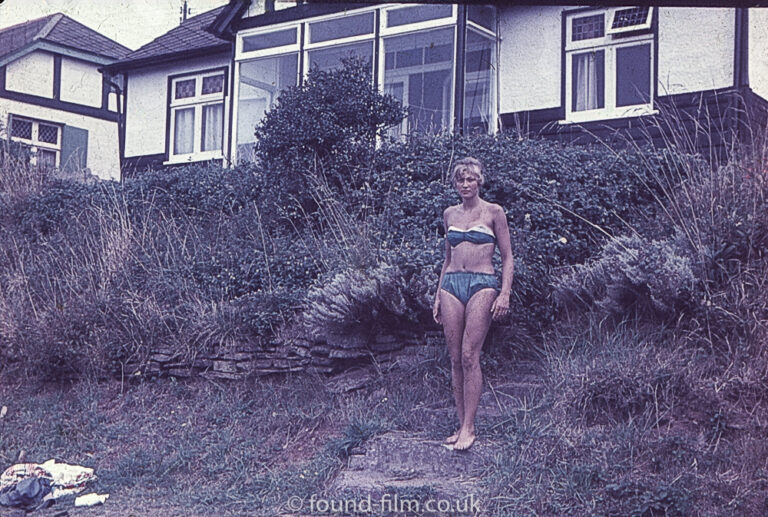 Girl in a bikini in front of a house