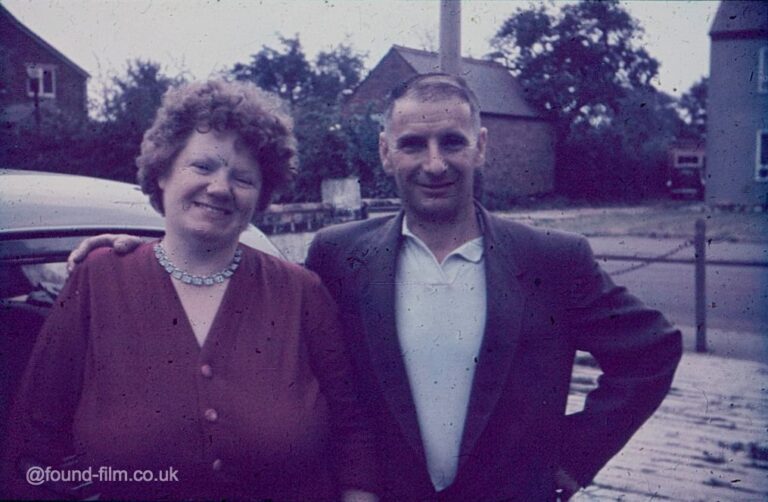 Couple standing by their car