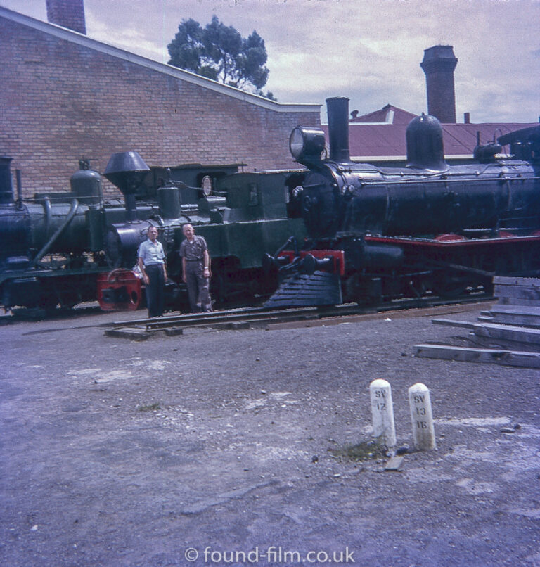 Two men standing by a Steam Engine