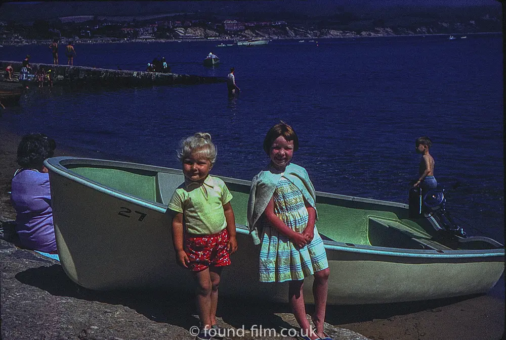 Two little girls standing by a boat
