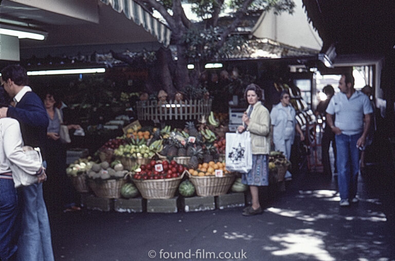 Woman buying fruit and veg from a market scene in May 1980