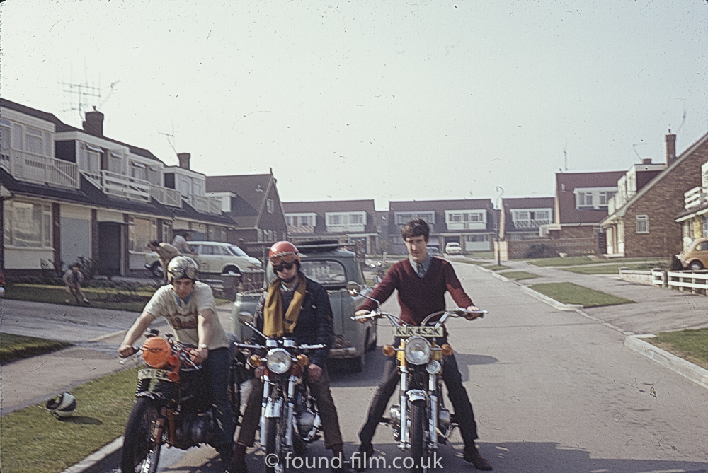 Men sitting on motorbikes in a housing estate, August 1972