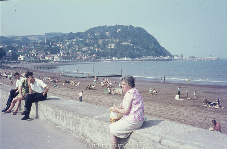 Lady sitting on the seawall at Minehead beach