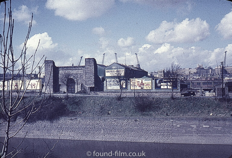 Riverside industrial area with billboards and cranes