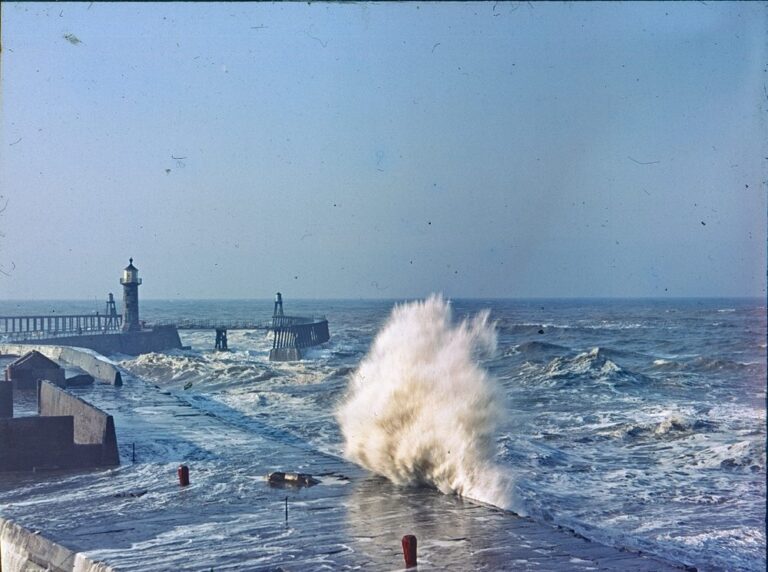 Sea breaking with lighthouse in the distance