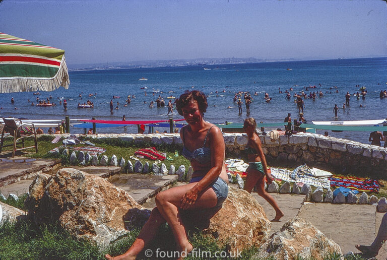 Woman sitting on a rock in a bikini in August 1969