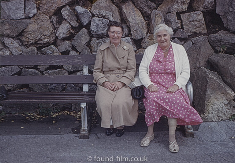 A portrait of two ladies on a bench