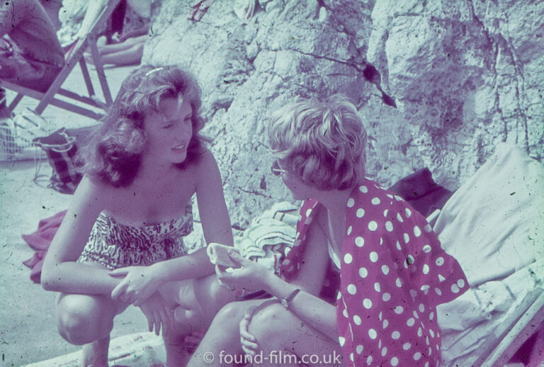 Two women chatting at the foot of a cliff