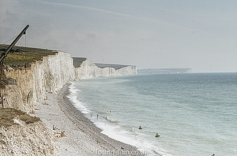 White cliffs and pebble beach with a crane