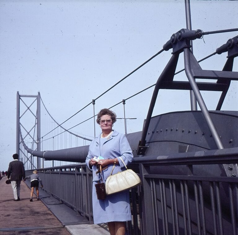 Woman standing next to an iron bridge