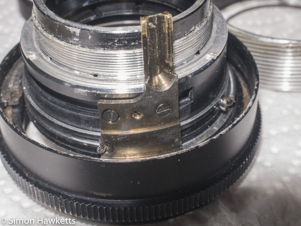 Auto Takumar 55mm f/2.2 strip down - The aperture actuation arm with broken spring
