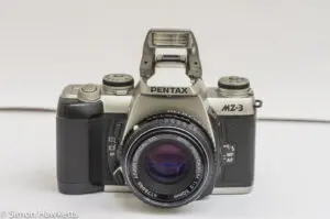 Front view of Pentax MZ-3 with manual focus SMC Pentax-M 50mm f/2 lens and flash up