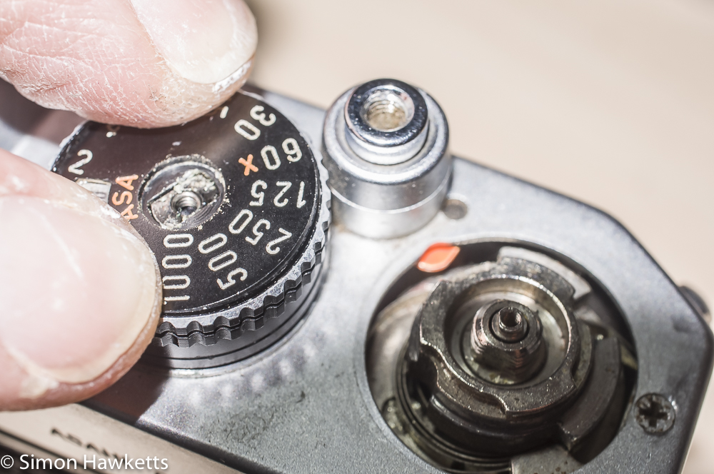 Hold onto the top of the shutter speed dial before you remove the centre screw