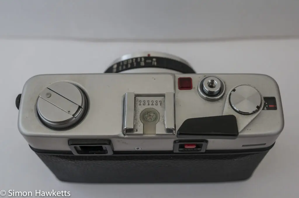 Minolta Hi-Matic F 35mm rangefinder camera showing shutter release, film advance and battery check