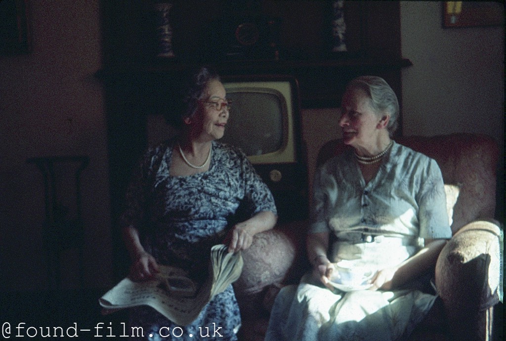 Two ladies chatting in front of the TV